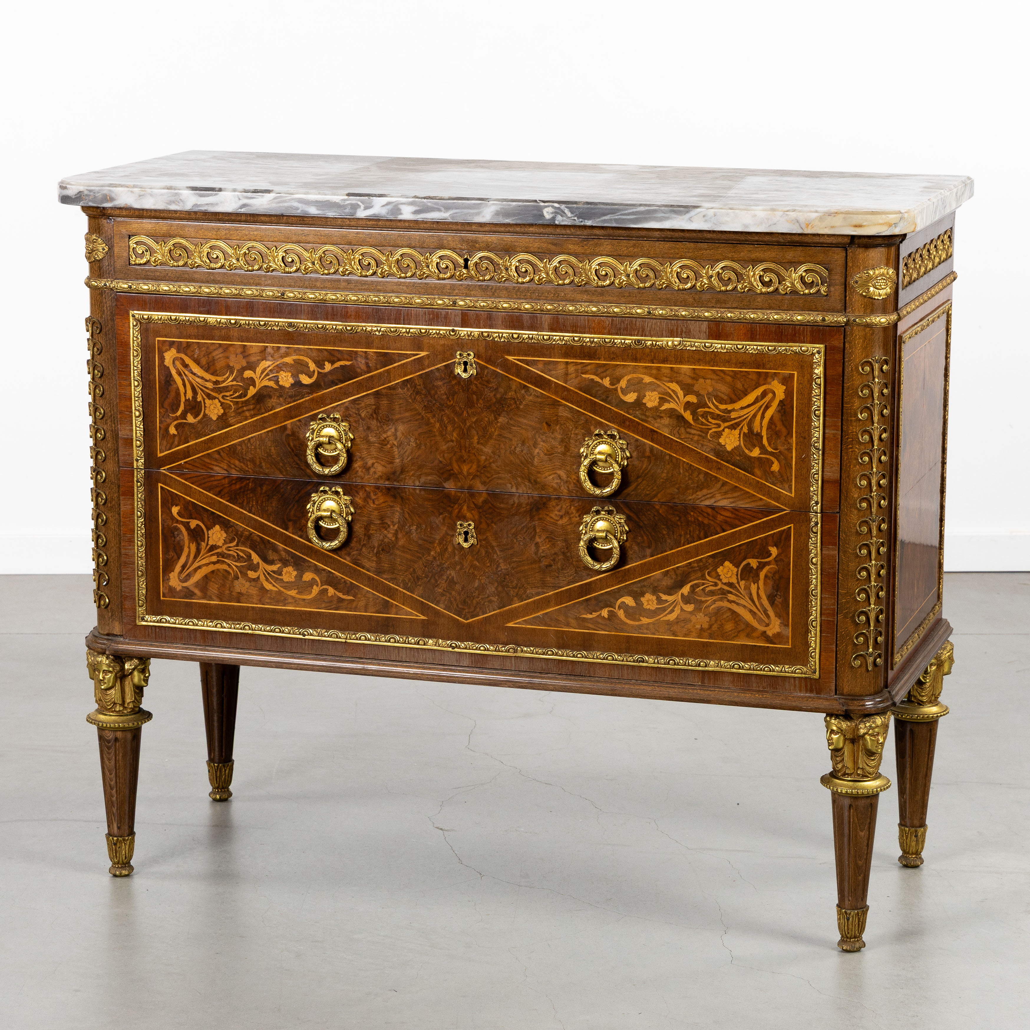 Een commode met marmeren blad, wortelhoutfineer, marqueterie en verguld bronsbeslag, Lodewijk XVI stijl, 20ste eeuw. (L:44 x W:101.5 x H:85 cm)